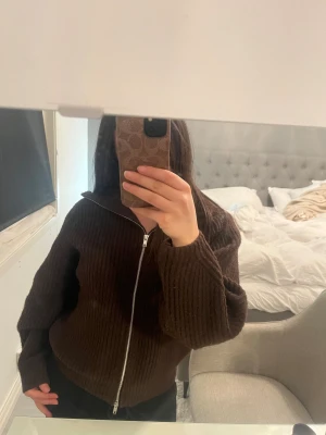 Mörkbrun stickad kofta med dragkedja - Säljer en mörkbrun zip up kofta från bikbok som är i bra skick och använd fåtal gånger, inga synliga defekter!