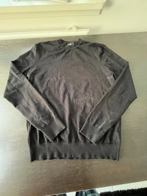 Svart basic långärmad  - En svart långärmad tröja i enkel och stilren design. Tröjan har rund halsringning, ribbade muddar vid ärmslut och nederkant. Perfekt att matcha med jeans eller under en jacka. Materialet är mjukt och skönt bomullstyg.