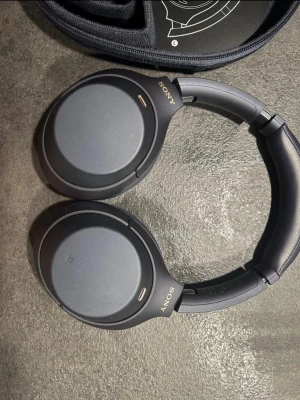 Sony WH-1000XM4 - Sony WH-1000XM4 trådlösa over-ear hörlurar med aktiv brusreducering. Mörkblå färg, levereras med originalfodral. Hörlurarna ser ut att vara i mycket gott skick utan synligt slitage eller defekter. Perfekt för musik, resor och arbete med lång batteritid och bekväm passform.