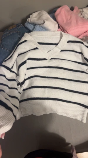 Vit och svart randig croppad tröja Shein - Säljer en croppad stickad tröja från Shein i storlek S. Tröjan är vit med svarta horisontella ränder, har v-ringad hals och långa ärmar. Perfekt för dig som gillar en chill och trendig look med lite loose passform.