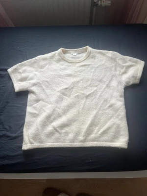 Vit stickad kortärmad tröja Gina Tricot - Vit stickad tröja från Gina Tricot i storlek 170. Tröjan har korta ärmar och rund halsringning med ribbad kant. Använd 3 gånger och är som ny. Inga hål helt intakt 