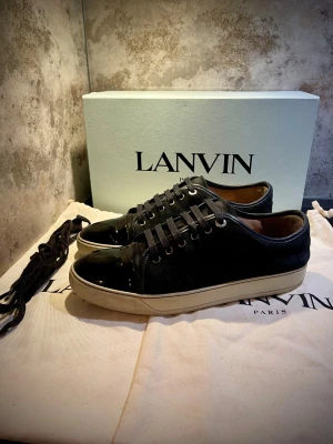 Lanvin Patent Cap toe sneakers - Säljer nu dessa riktigt snygga Lanvins i storlek UK 8 vilket motsvarar 42-43 ungefär 🙌 Mockan är i nästintill perfekt skick, sulan är vit och fin. Alla sömmar är intakt osv! Cap toen har inga repor alls! Enda defekten är en liten defekt på sulan i form av lite heeldrag på höger sko, vilket man ej lägger märke till vid första anblick eller känner av när man har på sig skorna🤩.  Perfekt till vinter❄️TILLBEHÖR:SKOLÅDA, 2ST DUSTBAGS, EXTRA SKOSNÖREN 😊 Skriv vid funderingar📲 kom gärna med prisförslag🙏