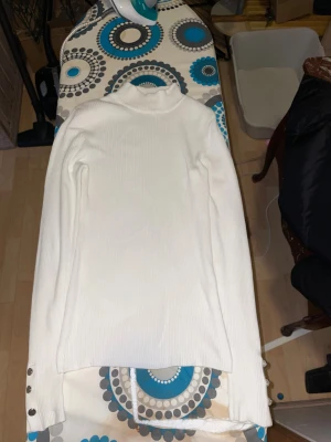 2 stycken Vit/svart ribbad polotröjor - Säljer en vit/svart ribbade polotröjor med långa ärmar och snygga silvriga knappar vid ärmsluten på den vita .tröjorna har en hög krage och är figurnära i modellen, perfekt för dig som gillar stilrena och enkla plagg med en twist.skulle säga att storleken är M-L, 120kr för båda 