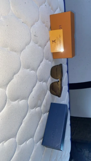 Bruna solglasögon från Louis Vuitton - Snygga bruna solglasögon från Louis Vuitton med fyrkantig form och breda skalmar. Märkesloggan är diskret ingraverad på båda sidor. Kommer med originalbox och certifikat. Perfekt accessoar för dig som vill sticka ut med stil.