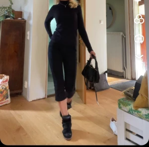 Svarta croppade jeansbyxor - Säljer ett par svarta capri med smal passform och låg midja. Byxorna har klassisk femficksdesign och är tillverkade i stretchigt jeanstyg som sitter snyggt och bekvämt. Perfekta för dig som gillar en stilren och modern look.