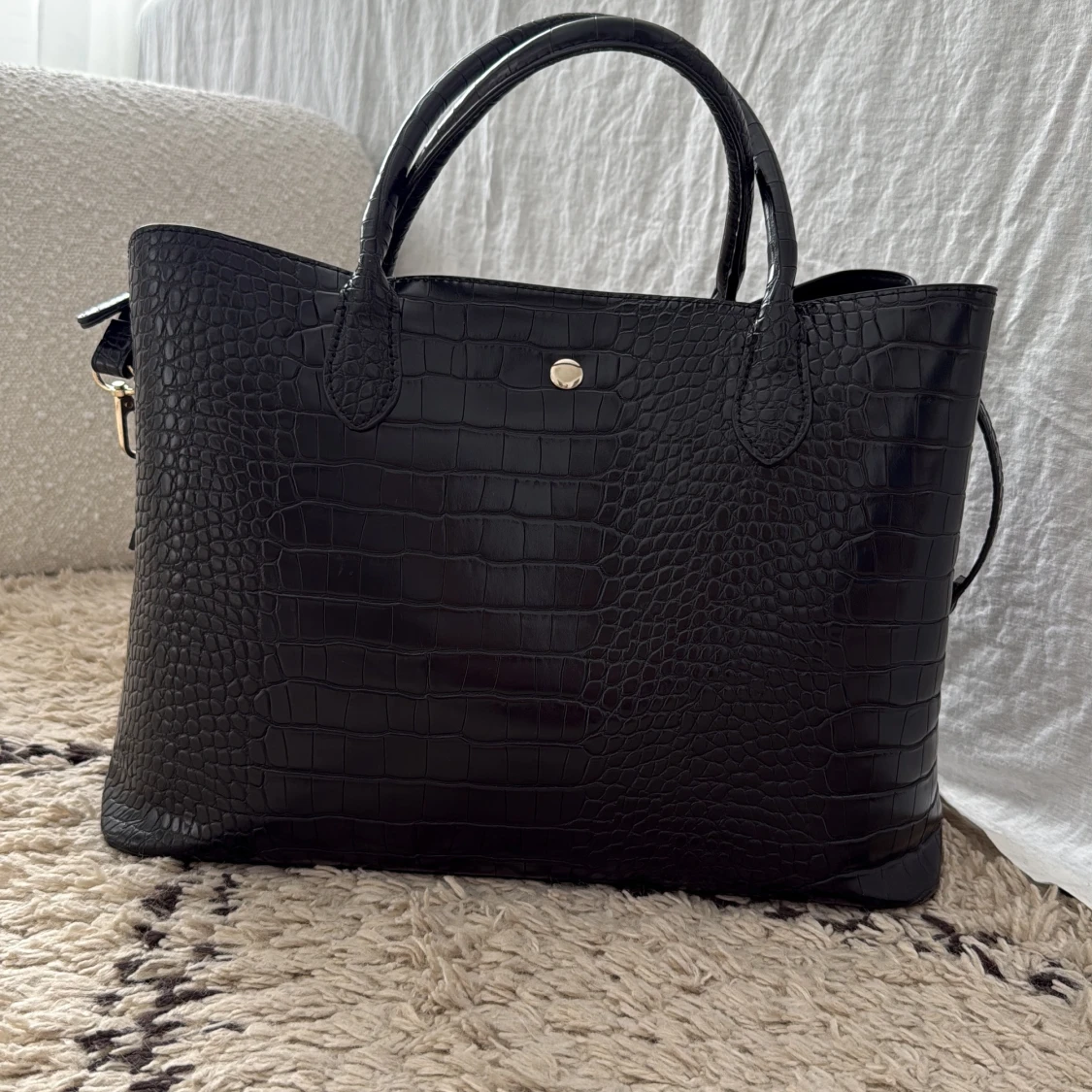 Svart handväska med crocomö-mönster