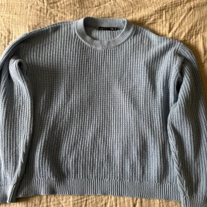 Tröja - Säljer en ljusblå stickad tröja från 157 med rund halsringning och ribbade muddar. Knappt använd och inga fläckar eller slitage.