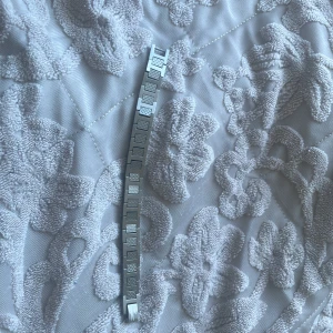 Silvrigt armband med rutiga länkar - Snyggt lacoste armband i silverfärg med rektangulära länkar som har ett rutigt mönster. Armbandet har en stilren och modern design som passar perfekt till din vardagsstil. Länkarna är platta och blanka med diskreta detaljer. Använd i 1 vecka. Vill bli av så fort som möjligt 