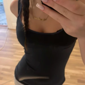 Svart linnetopp från The Essentials - Säljer en marinblå, tight och basic linnetopp från The Essentials. Toppen är ärmlös med smala axelband och har en klassisk, enkel design som funkar till allt. Tillverkad i mjuk bomull som känns skön mot huden.