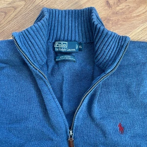 Blå half zip tröja från Polo Ralph Lauren - Säljer en blå långärmad tröja från Polo Ralph Lauren i 100% bomull. Fick den från min pappa men tyvärr för stor för mig. Själv runt 183 cm. Bra skick och riktigt snygg polo quarter zip. 