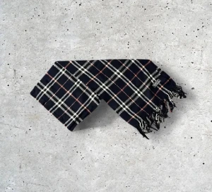 Mörkblå Burberry scarf - Säljer en snygg Burberry halsduk med det ikoniska rutmönstret. Tillverkad i 100% mjuk och värmande ull.   🧵 Skick: Mycket fint skick, varsamt använd 🌟 Känsla: Mjuk, varm och följsam 📦 Frakt: Skickas tryggt inom 24h 📏 Mått: Längd-150cm, Bredd-30cm Pris kan diskuteras!