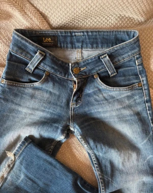 Blå Lee jeans med bootcut - Snygga lågmidjade jeanse från Lee. Innerbenslängden: 81 midjemått: 34