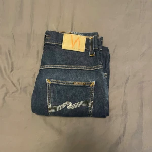 Mörkblå jeans från Nudie - Snygga jeans från Nudie, storlek W31, L32. Lägg märke till ett litet hål men som har lagats (se sista bild) men det är inget man märker när man använder de. Thin Finn