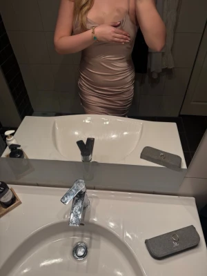 Champagnefärgad satin klänning Missguided - Säljer en snygg champagnefärgad kort klänning från Missguided i satin med smala axelband och v-ringad hals. Klänningen har draperade detaljer och snörning på sidan. Perfekt för dig som vill ha en klänning till nyår eller annat💗