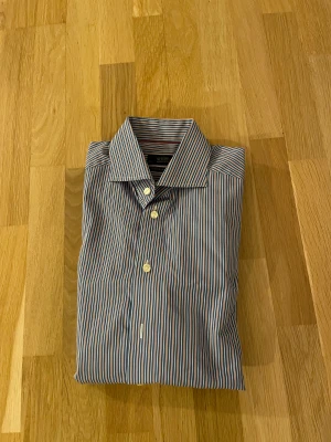 Randig skjorta från Eton, blå/röd - Snygg skjorta från Eton i contemporary fit. Nypris ca 1700kr mitt pris endast 199 kr. Fraktar inom 1 dag, om du har någon fundering så är det bara att höra av sig😊