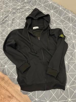 Svart stone Island zip tröja  - Säljer nu min svarta stone Island tröja pga den inte passar längre, storleken är M och den passar runt 170-185cm lång, modellen på bilden är 187 cm väger 70, inga defekter 