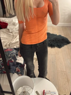 Orange topp med fyrkantig ringning - Säljer en orange topp från Gina tricot med snygg fyrkantig ringning och halvlånga ärmar. Modellen är slim och sitter tajt mot kroppen. Materialet är mjuk bomull som känns skönt mot huden. Perfekt för dig som gillar färg och vill sticka ut lite extra på ett positivt sätt. 