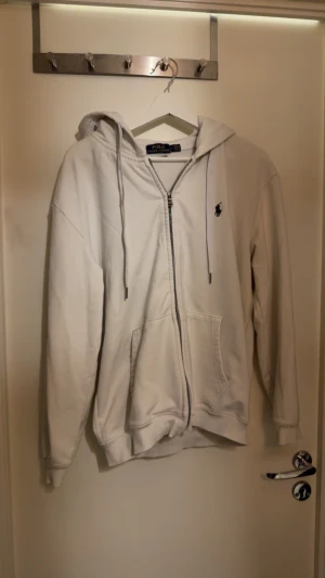 Vit hoodie från Polo Ralph Lauren - Säljer nu min Polo Ralph Lauren tröja då den inte passar mig längre. Storlek L men känns mer som M om du frågar mig. Väldigt bra skick använt fåtal gånger o varit väldigt rädd om den. Priset är diskuterbart men inga skambud tack