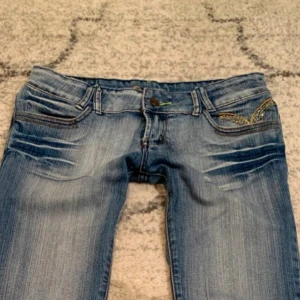 Low Rise jeans  - Ljusblåa lågmidjade jeans med jättesnygga detaljer på bakfickorna! Vintage byxor från Divine