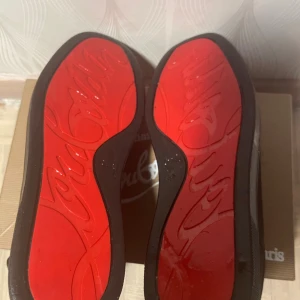 Christian Louboutin Louis Strass sneakers - Säljer ett par svarta Christian Louboutin Louis Strass sneakers med ikonisk röd sula och coola nitar på ovansidan. Skorna är tillverkade i mocka och har snörning. Kommer med originalkartong, dustbag och äkthetskort. Perfekt för dig som vill sticka ut med lyxiga detaljer.