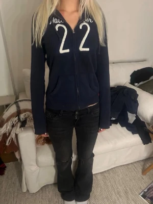 Mörkblå Hollister hoodie med dragkedja - Trendig zip-up från Hollister. Fint figursydd