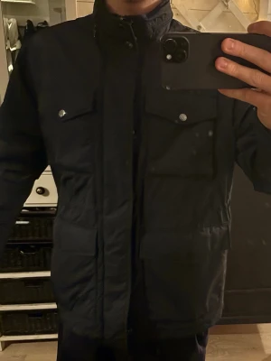 J Lindberg Field jacket  - Säljer nu denna oanvända J Lindberg Field jacket i storlek L. Luva finns inbyggd. Pris kan diskuteras vid snabb affär! Köpt för 4 förra vintern.