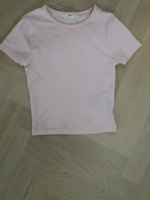 Ljusrosa basic t-shirt - En enkel och ljusrosa t-shirt med rund hals och korta ärmar.