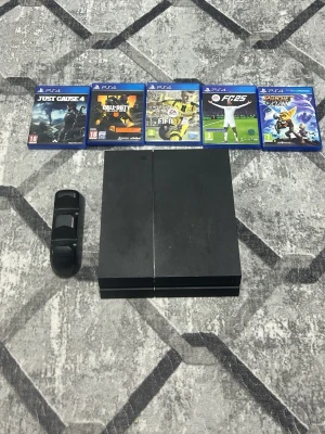 Playstation 4 med spel och laddstation - Säljer en svart Playstation 4 med klassisk kantig design. Konsolen är tillverkad i plast och kommer med fem PS4-spel (Just Cause 4, Call of Duty, FIFA 17, FIFA 15, Ratchet & Clank) samt en laddstation för handkontroller.