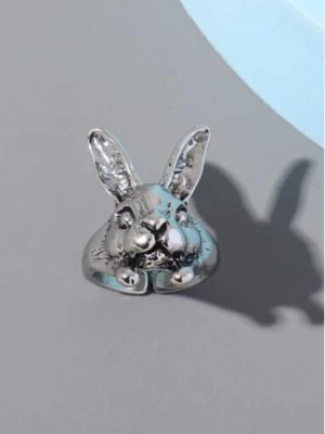 Silvrig ring med kaninform - Unik ring i silverfärgad metall med en detaljerad kaninform framtill. Ringen har upphöjda öron och ansiktsdrag som ger ett lekfullt och trendigt uttryck. Perfekt för dig som gillar djurmotiv och vill sticka ut med dina accessoarer.