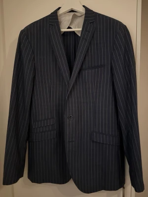 Blå kritstrecksrandig kavaj  - Snygg blå kavaj från tiger of Sweden med vita kritstrecksränder. Storlek 50 