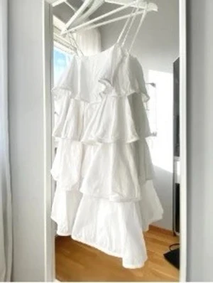 Vit volangklänning med smala band Zara M studentklänning  - Söt vit klänning med flera lager volanger och smala axelband. Så fin till studenten! Inga defekter! 