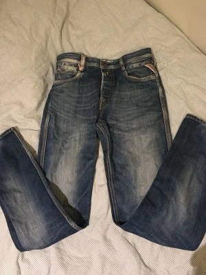 Replay jeans - Säljer ett par klassiska blå raka Replay jeans Jeansen kontrastsömmar och Replay-märke bak i midjan. Perfekta för dig som gillar en avslappnad och archive stil.