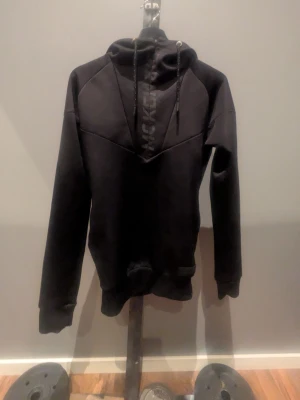 Svart hoodie från McKenzie - Snygg svart hoodie från McKenzie med tryckt logga på bröstet. Hoodien har huva med dragsko och långa ärmar. Tillverkad i mjukt material som känns bekvämt mot huden. Perfekt för en avslappnad och sportig stil.