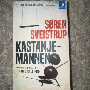 Kastanjemannen av Søren Sveistrup - 🛑Obs Boken är inte smutsig den skal vara så 🛑En spännande deckare av Søren Sveistrup där en kvinna hittas mördad på en lekplats i Köpenhamn. Omslaget är vitt med svarta och röda bokstäver samt en bild på en kastanjefigur. Pocketbok i klassiskt format.
