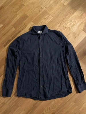 Mörkblå skjorta med knappar - Snygg mörkblå Bläck skjorta, väldigt mjukt och mysigt material som passar för alla årstider, köpt väldigt nyligen.