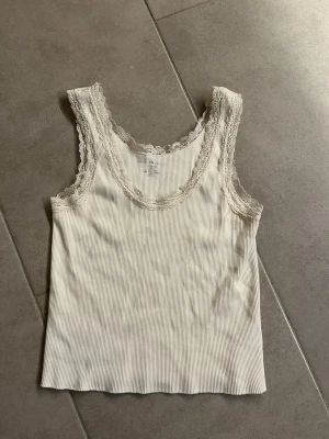 Vitt linne med spets  - Supersöt vitt linne med spets från brandy Melville i one size men passar XS/S (modellen är kort) 