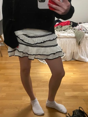 Vit volangkjol med svarta detaljer - Supersöt kortkjol i vitt med flera volanglager och svarta detaljer säljer även den matchande toppen till ❤️❤️