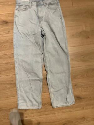Ljusblå raka jeans i bomull från hm - Säljer ett par ljusblå jeans från HM med rak passform och klassisk femficksdesign. Jeansen har hög midja och är tillverkade i mjuk bomull. Perfekta för en avslappnad och trendig look.