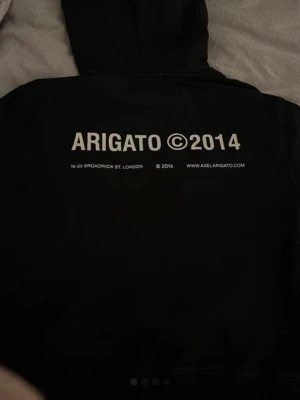 Arigato hoddie - Svart äkta hoodie från Axel Arigato i snygg, minimalistisk design. Tryck bak och liten logga fram. Mjuk och bekväm, i fint skick. Perfekt till vardag eller en clean streetstyle-look. 💞