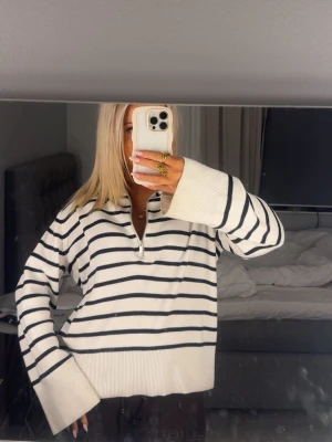 Randig half zip stickad tröja - Säljer en vit stickad tröja med svarta horisontella ränder och half zip-dragkedja. Perfekt för dig som gillar en chill och stilren look. Från Kappahl i storlek XS, nypris: 499 kr. Som ny i skicket då den enbart är använd 2 gånger.