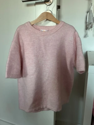 Ljusrosa stickad tröja Gina Tricot - Supersöt ljusrosa stickad tröja från Gina Tricot med korta ärmar och rund hals. Storlek 158/164