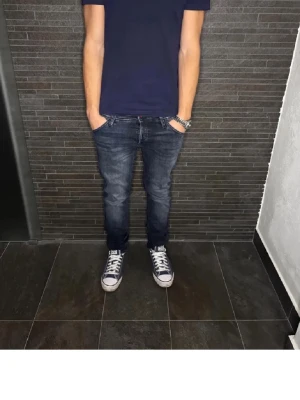 Mörkblå slim straight jeans - Säljer ett par mörkblå jeans med snygg tvätt och klassisk femficksdesign. Jeansen har en rak passform med lätt slim känsla och normal midja. Perfekta till sneakers och t-shirt för en avslappnad look.