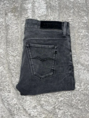 Replay jeans  - Mörkgråa replay jeans I skinny passform. Midja 35cm, längd 95cm. JAG SKICKAR EJ FLER BILDER NÄR JAG BÄR JEANSEN! för bättre inblick i passformen rekommenderar jag att googla på modellnamnet. För storleksguide kolla måtten noggrant då jeansen alltid kan vara uppsydda heller krympta och jag ej tar emot returer :) s6,1