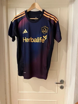La Galaxy away shirt 25/26 - Säljer en riktig fet LA Galaxy away fotbollströja helt nytt skick och tags kvar. Perfekt för dig som vill ha en unik/exclusive fotbollströja. Vill du ha eget tryck och ditt namn där bak, kontakta: monclique_uf på instagram!🥂