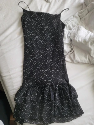 Svart prickig volangklänning - Söt svart klänning med prickar och volanger. Köpt på vinted utan märke. Midi längd.