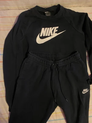 Nike Set  - Bilderna visar ett svart Nike-set med sweatshirt och byxor, använd men den är i jättebra skick. Pris kan diskuteras! Den är unisex.!