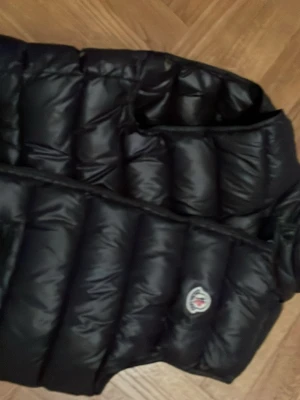 Svart dunväst från Moncler - Säljer en svart äkta dunväst från Moncler. Helt nytt skick då den ej passade mig. Västen har en glansig finish och är perfekt för lager-på-lager under kyliga dagar. Snygg och tidlös modell som funkar till det mesta. Nypris 3800. Mitt pris 700 kr