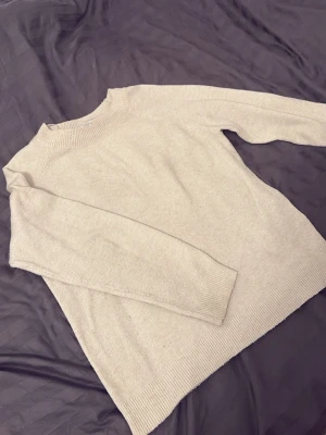 Beige stickad tröja från ONLY - Mysig beige stickad tröja från ONLY i storlek M. Tröjan har rund halsringning, ribbade muddar och är långärmad. Perfekt för lager på lager under kyliga dagar och enkel att matcha med allt. Jätte fin men tyvärr är den stor på mig så kommer ej till användning. Använd några gånger men fortfarande fin och i bra skick.