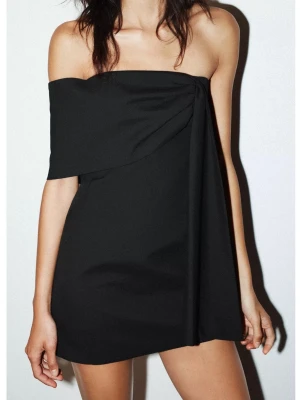 Svart offshoulder miniklänning - Trendig svart kortklänning med asymmetrisk offshoulder-design med detalj över ena axeln. Prislappen sitter kvar. 