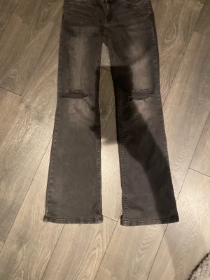 Svarta bootcut jeans från Nelly - Säljer ett par svarta bootcut jeans från Nelly. Dom är LITE trasiga se bild 4&5.  Storlek 36. Jag säljer dom för att dom inte kommer till användning. Priset går att diskutera kan tänka mig att sälja dom för 250 som minst. 